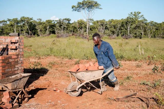 Moving materials across the site by wheelbarrow